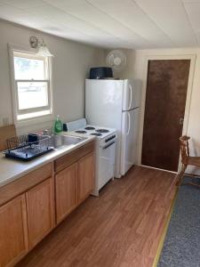 a kitchen with a white refrigerator and a sink at Inn at the Isles in Isle la Motte