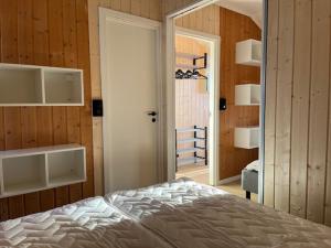 a bedroom with a bed in a room with wooden walls at Nordseter Fjellpark, Hyttegrend in Nordseter