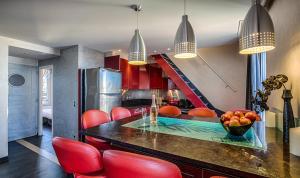 a kitchen with red chairs and a table with a bowl of fruit at RG Duplex - LRA Cannes in Cannes
