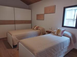 a bedroom with two beds and a window at Vistas a Cangas in Cangas de Onís