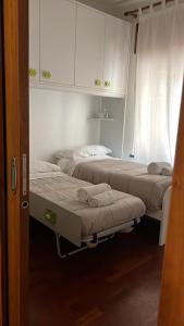 two beds in a room with white cabinets at Bis Jolly 1 in Cosenza