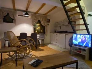 a living room with a tv and a table with chairs at Vila Krnjević Jastrebac in Buci