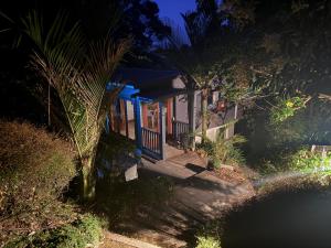 a small house with a blue door at night at Little Palm Beach Hideaway in Waiheke Island