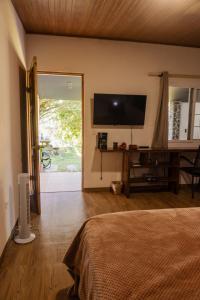 a bedroom with a bed and a flat screen tv at La Dama de los vientos in Cerro Azul