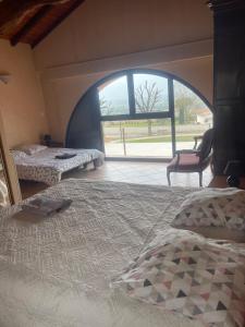 a bedroom with two beds and a large window at Chez Papi in Bazus