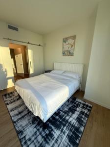 a bedroom with a large white bed and a rug at Luxe Apartment with Harbor views in Baltimore