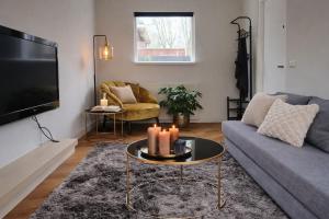 a living room with a couch and a tv at Bergen Delight in Bergen +5 photos