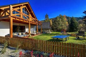 a house with a ping pong table in the yard at Chalet Oasis at Chalets Kvačianska dolina in Zuberec
