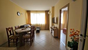 a dining room with a table and chairs and a living room at Milushevi apartment in Golden Sands