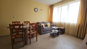 a living room with a couch and a table and chairs at Milushevi apartment in Golden Sands +15 photos