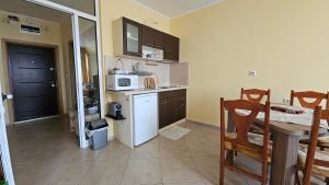 a kitchen with a white refrigerator and a microwave at Milushevi apartment in Golden Sands