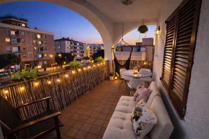 a balcony with a couch and a table and lights at Blue House Calafell in Calafell