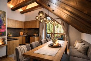a kitchen and dining room with a table and chairs at Chalet Oasis at Chalets Kvačianska dolina in Zuberec