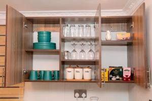 a kitchen cabinet filled with lots of dishes and glasses at Asili House in Sagana