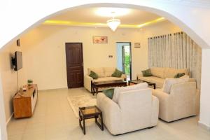 a living room with two couches and a tv at Asili House in Sagana