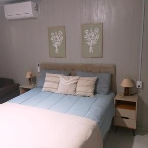 a bedroom with a bed with two night stands and two lamps at Casa de verão vó judite -praia Sulmar- 4 quartos in Balneário Gaivotas