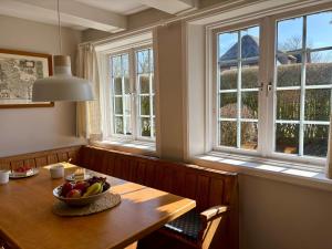 a dining room with a table with a bowl of fruit on it at Altes Friesenhaus West in Morsum