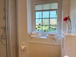 a bathroom with a window and towels on a window sill at Altes Friesenhaus Scheune in Morsum +36 photos