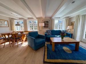 a living room with a blue couch and a table at Altes Friesenhaus West in Morsum