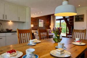 a kitchen and dining room with a wooden table with cakes at Altes Friesenhaus Scheune in Morsum