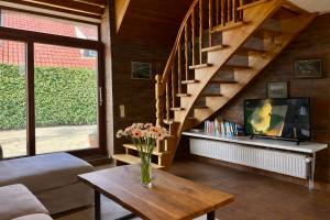 a living room with a staircase and a vase of flowers on a table at Altes Friesenhaus Scheune in Morsum