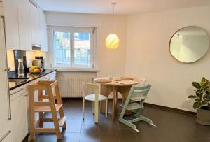 a kitchen and dining room with a table and chairs at Central and well connected modern studio in Zurich