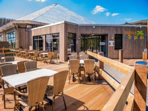 a restaurant with tables and chairs on a deck at Hambachtal nature hideaway boutique resort in Oberhambach
