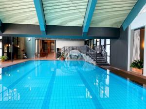 a large swimming pool in a building at Hambachtal nature hideaway boutique resort in Oberhambach