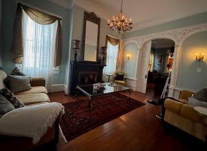 a living room with a fireplace and a chandelier at The Dragonfly Tremé-Historic Guesthouse-Near French Quarter in New Orleans