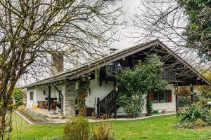 a white house with a porch and a yard at Landhausvilla Watzmannblick in Saaldorf-Surheim