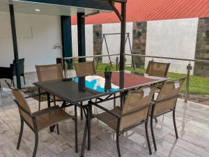 a black table and chairs with a vase on it at Hotel Parador El Tucán in Parana