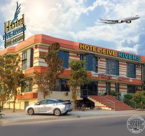 a car parked in front of a hotel with an airplane at Hotel Five Rivers - 2 Min to Allama Iqbal International Airport, Lahore in Lahore
