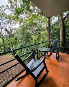 a balcony with a bench and a table and trees at Hotel Manuel Antonio Beracha in Quepos
