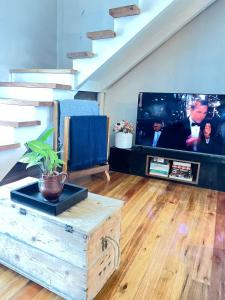 a living room with a tv and a wooden coffee table at Hospedaria Casa Verde in Itapoa