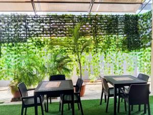 two tables and chairs in a room with plants at Servy Hotels in Port Harcourt +15 photos
