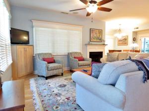 a living room with a couch and chairs and a fireplace at Cedar Cottage in Cape May Point