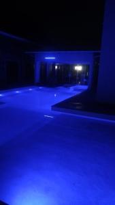 an empty parking lot at night with blue lights at Dunas beach club in Jaguaruna