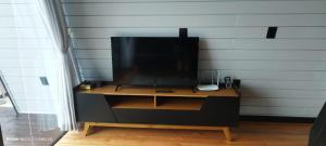 a tv sitting on a stand in a room at Dunas beach club in Jaguaruna
