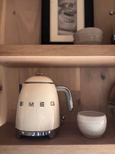 a tea kettle and a cup on a shelf at AURA Retreat Iceland in Hvolsvöllur