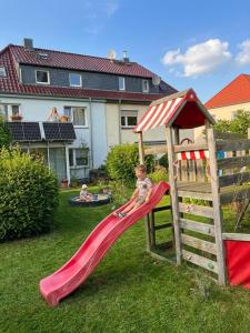 a child sliding down a slide on a playground at Gemütliche Ferienwohnungen Teterow für bis zu 10 Personen in Teterow