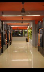 a large room with a hallway with tables and chairs at Aostel in Chennai