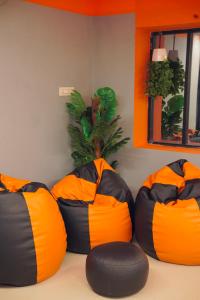 three orange and black bean bags in a room at Aostel in Chennai
