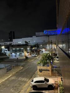 a white car parked in front of a building at night at Flat Manaira in João Pessoa