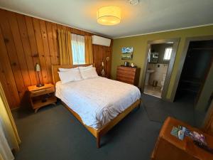 a bedroom with a large bed and a bathroom at Priest Station Cafe & Cabins in Groveland