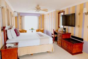 a bedroom with a bed and a flat screen tv at Hotel Plaza Colonial in Campeche