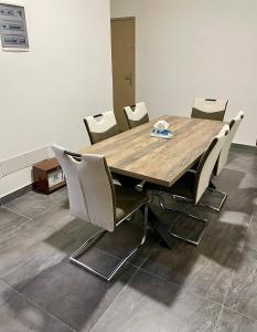 a wooden table and chairs in a room at Residence EBENE in Kika