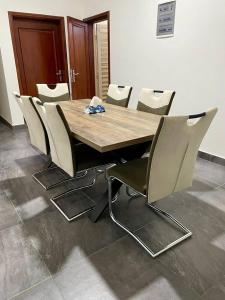 a wooden table and chairs in a room at Residence EBENE in Kika