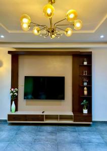 a living room with a flat screen tv on a wall at Residence EBENE in Kika