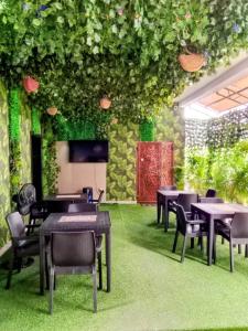 a restaurant with tables and chairs and plants at Servy Hotels in Port Harcourt