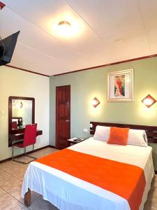 a hotel room with a bed and a mirror at Hotel Miami CR in Puerto Limón